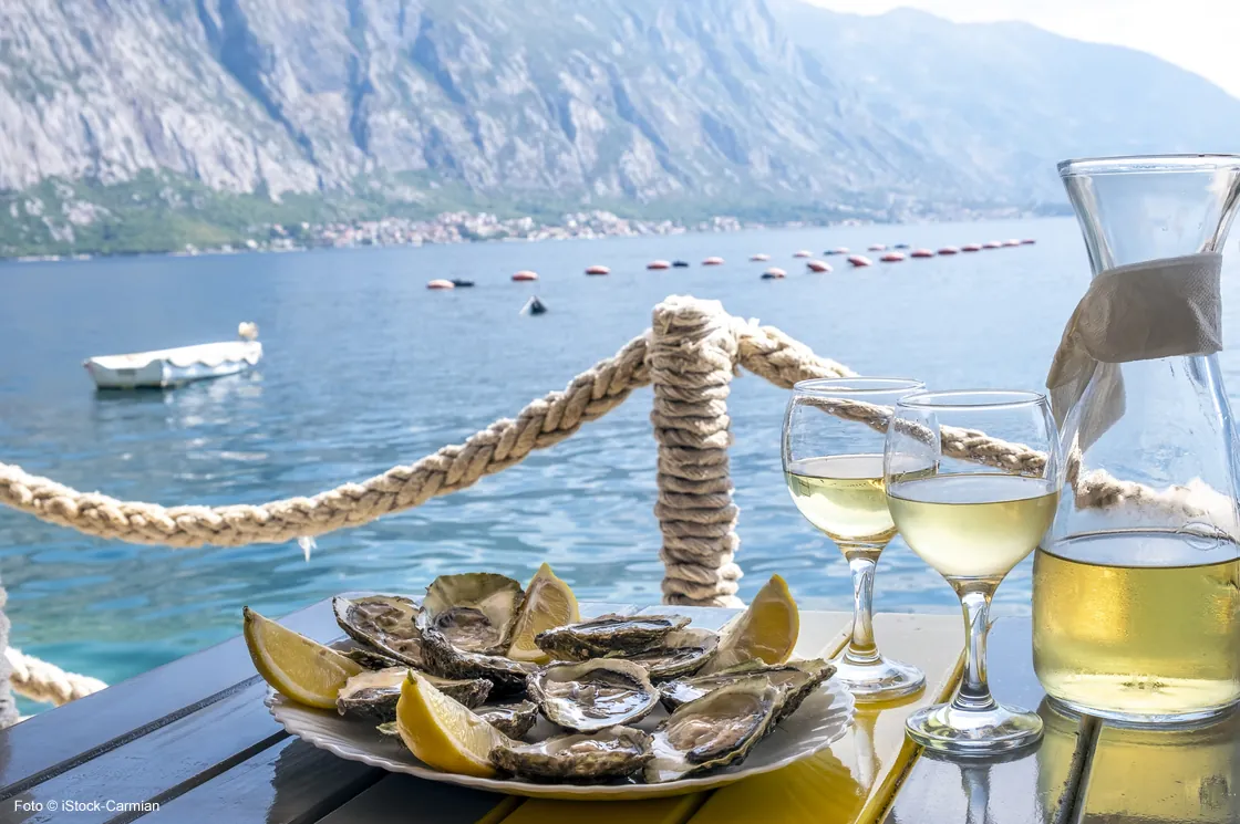 Austern und Weißwein in einem Restaurant mit Meerblick