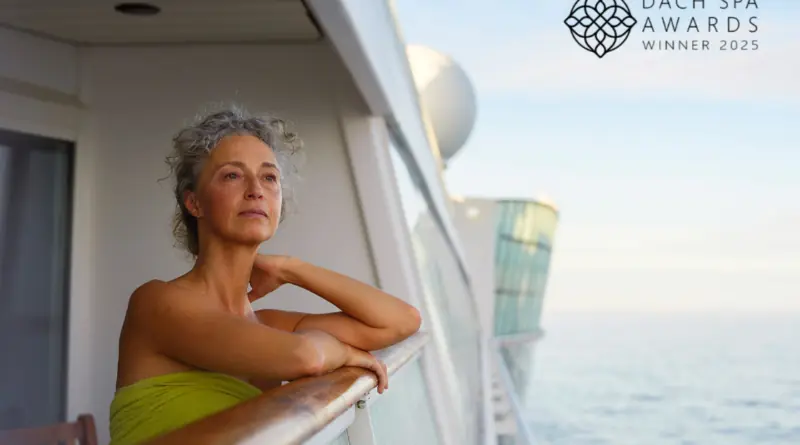 Eine Frau in einem grünen Handtuch lehnt entspannt am Balkon eines AIDA Kreuzfahrtschiffs, rechts oben das Logo „DACH Spa Awards Winner 2025“.