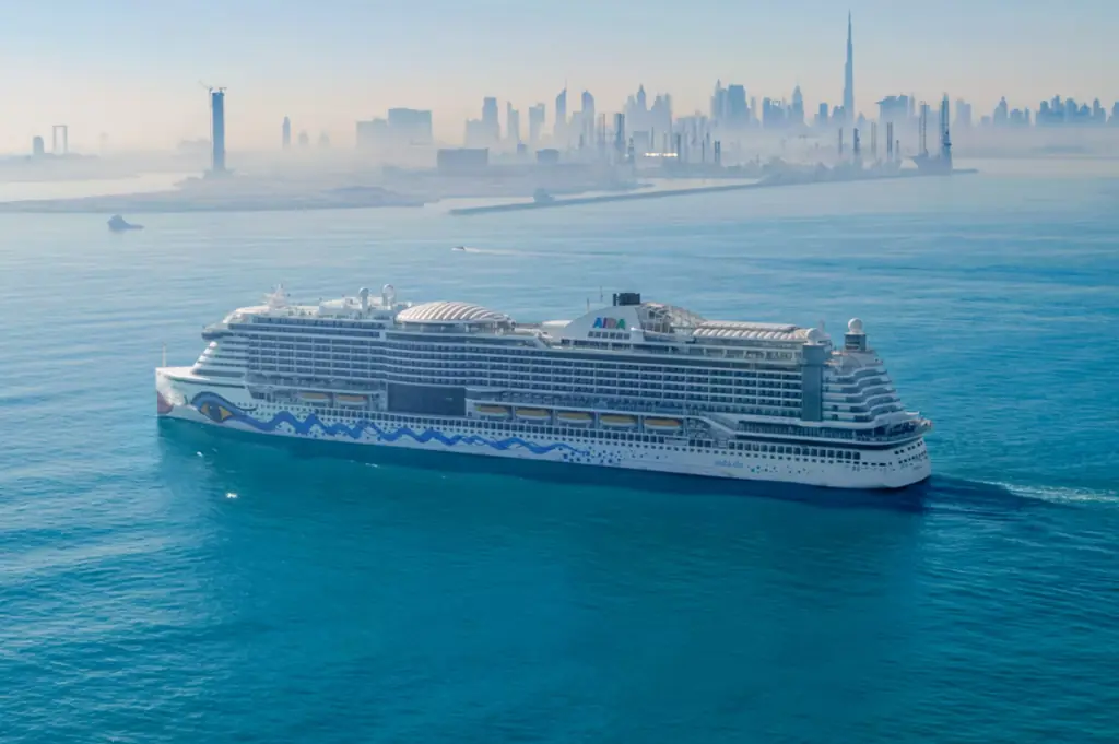 AIDAperla vor der Skyline von Dubai auf einer Kreuzfahrt im Orient.
