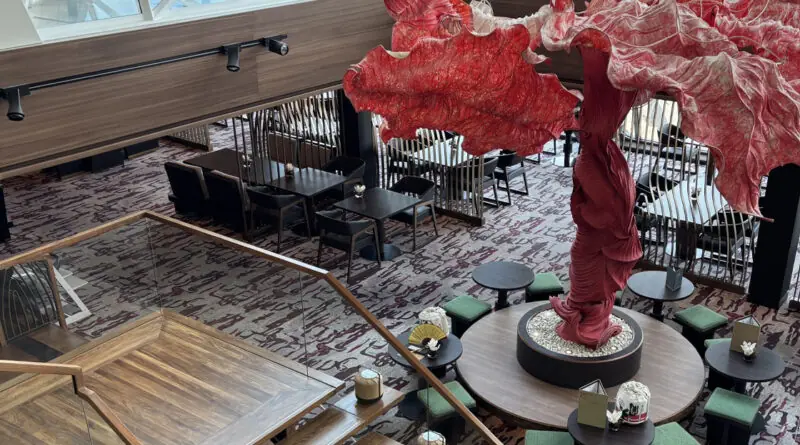 Modernisierter Hanami-Bereich auf der Mein Schiff 5 mit auffälliger roter Skulptur und stilvollen Sitzbereichen.