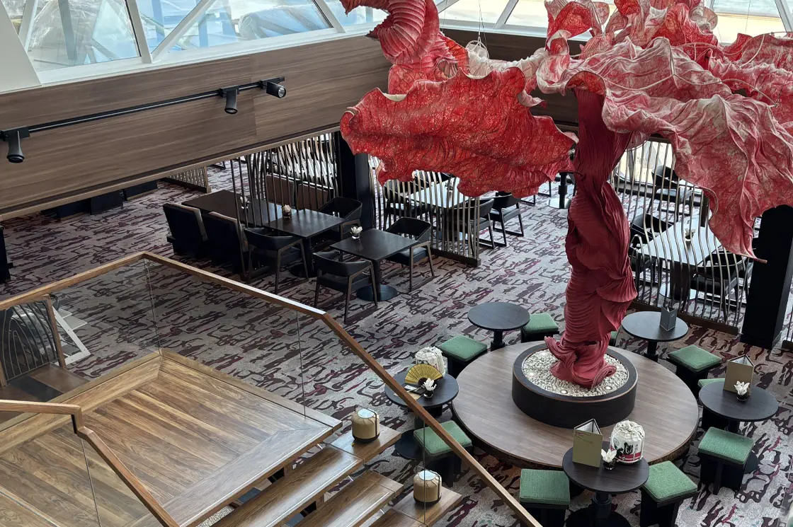 Modernisierter Hanami-Bereich auf der Mein Schiff 5 mit auffälliger roter Skulptur und stilvollen Sitzbereichen.
