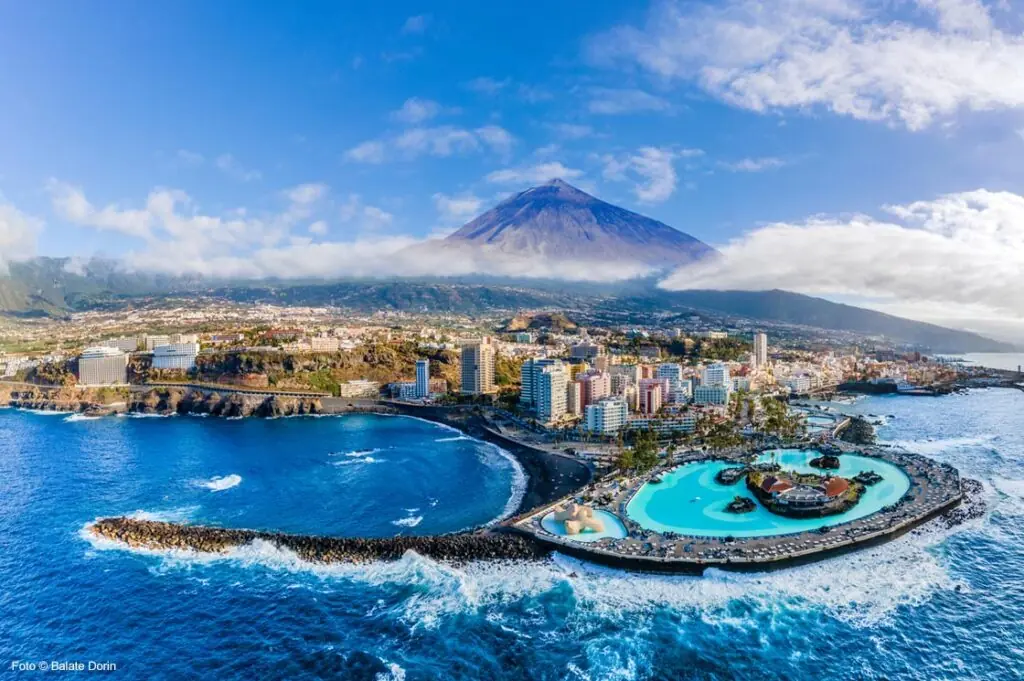 Luftaufnahme von Puerto de la Cruz auf Teneriffa mit Meerwasserpools und dem Teide im Hintergrund.